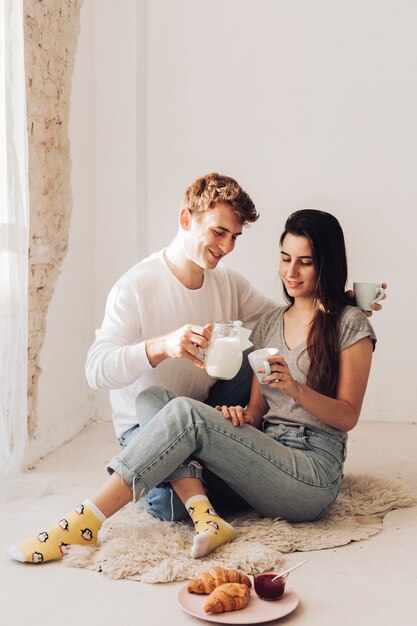 Junge serviert milch zu seiner freundin
