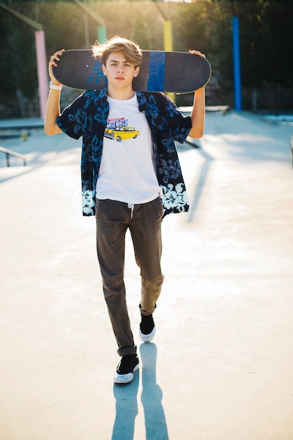 Kostenloses Foto junge skater posiert mit seinem skateboard