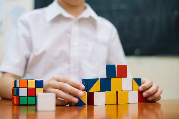 Junge spielt mit Puzzles am Schreibtisch