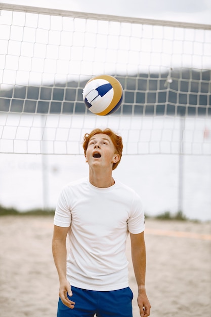 Junge spielt Volleyball am Hof