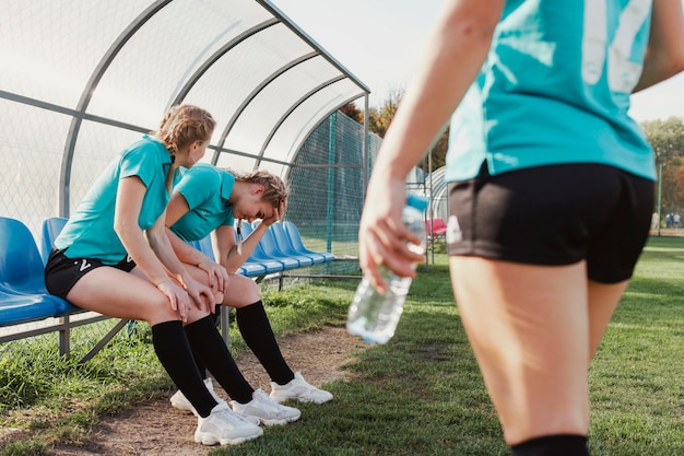 Kostenloses Foto junge sportive frauen, die auf einer bank stillstehen