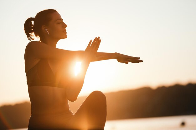 Junge Sportlerin, die morgens trainiert und ihre Arme streckt