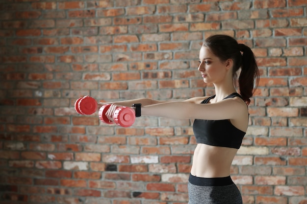 Junge Sportlerin mit Hanteln