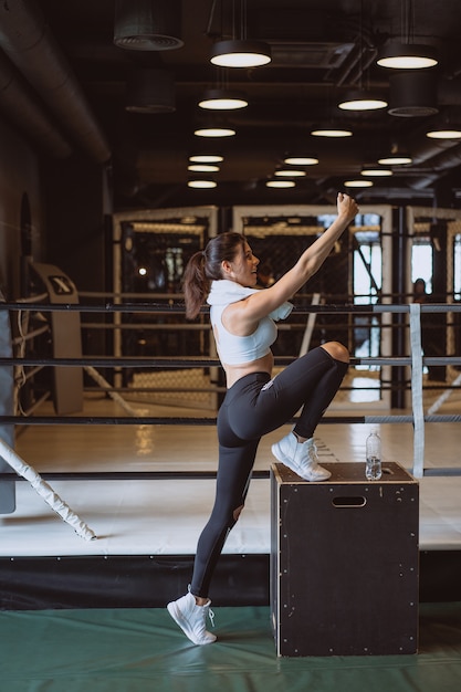 Junge sportliche Frau, die ein selfie mit Handy im Fitnessstudio nimmt.