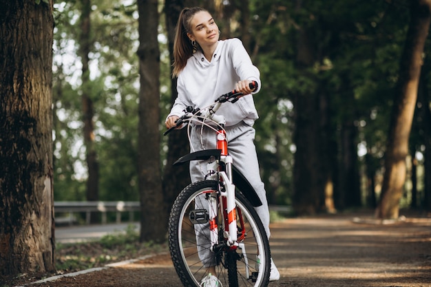 Junge sportliche Frau, die Fahrrad im Park reitet