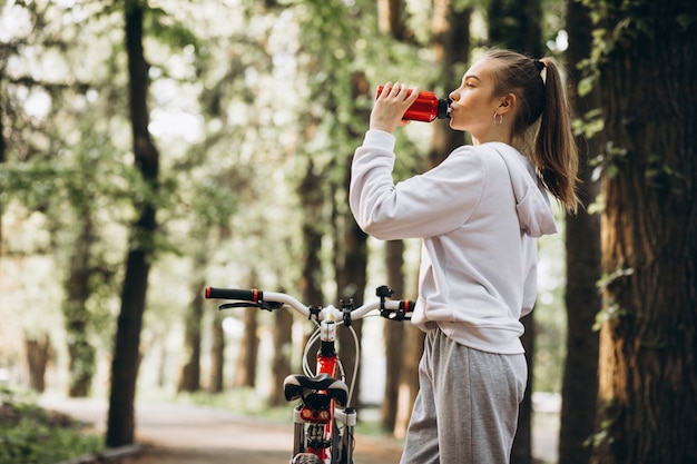 Kostenloses Foto junge sportliche frau, die fahrrad im park reitet