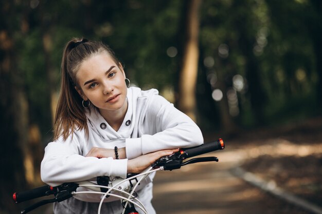 Junge sportliche Frau, die Fahrrad im Park reitet