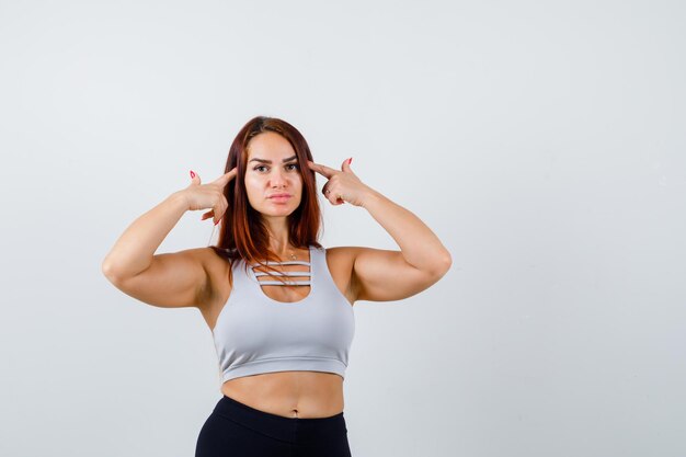 Junge sportliche Frau in einem grauen Top