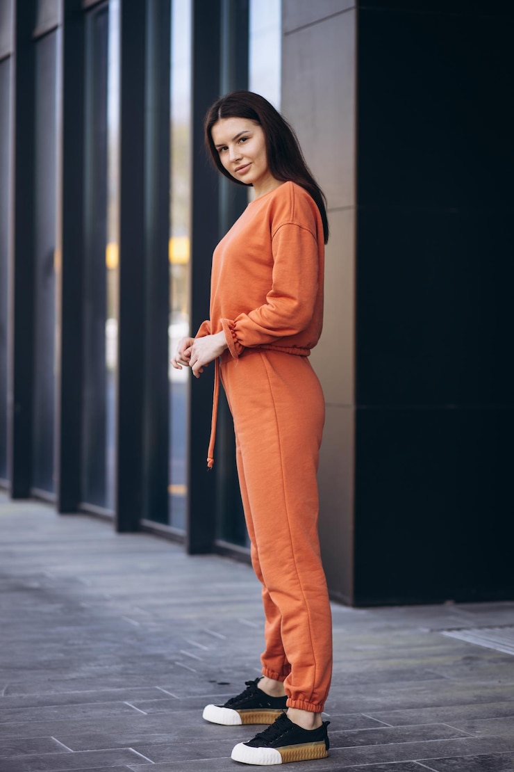 Kostenlose Foto junge sportliche frau in einem orangefarbenen sportanzug