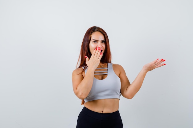 Junge sportliche Frau mit langen Haaren in einem grauen Top