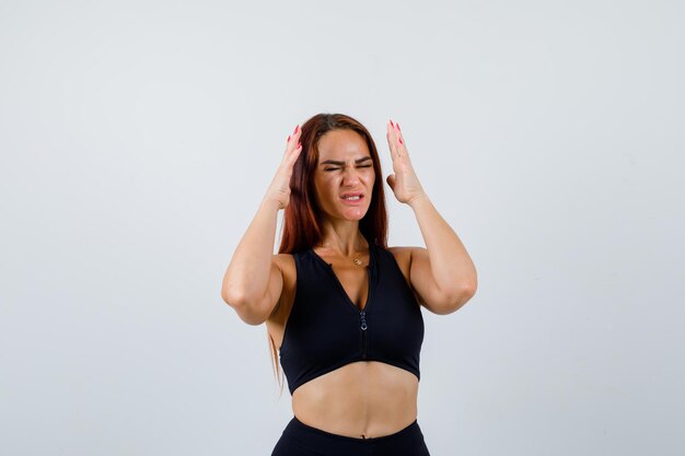 Junge sportliche Frau mit langen Haaren in einem schwarzen Top