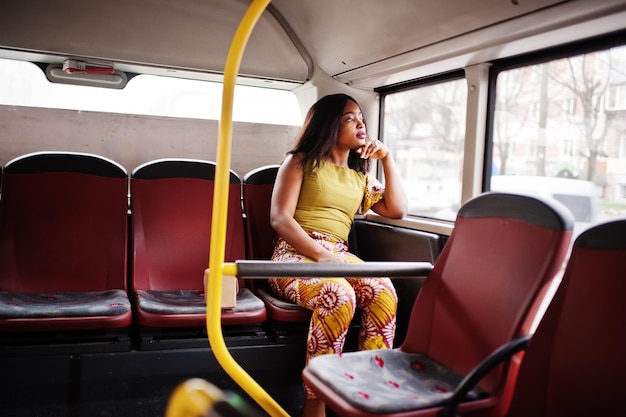 Junge, stilvolle Afroamerikanerin, die in einem Bus fährt