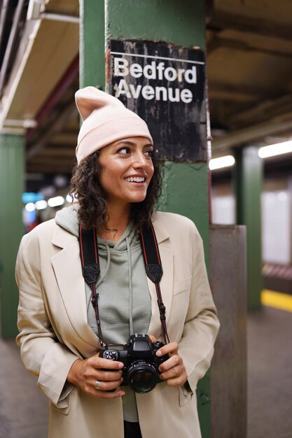 Junge stilvolle Fotografin, die die U-Bahn in der Stadt erkundet