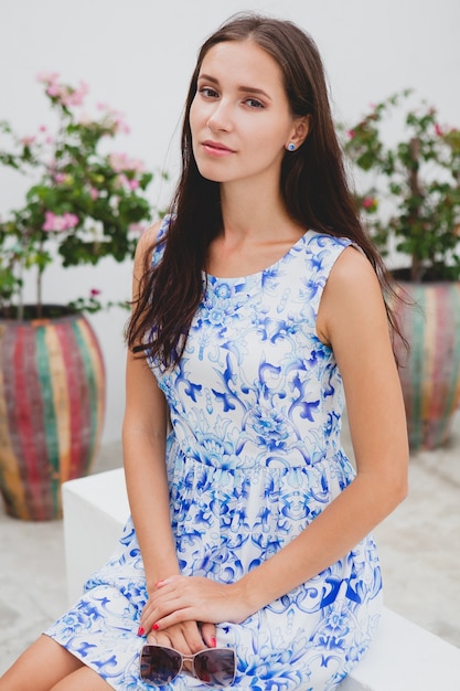 Junge stilvolle schöne Frau im blau bedruckten Kleid, Sonnenbrille, fröhliche Stimmung, Mode-Outfit, trendige Kleidung, lächelnd, Sommer, Accessoires