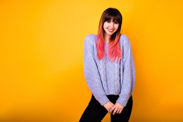 Junge stilvolle wunderbare Hipsterfrau mit langen ombre Fuchsia Haaren posiert