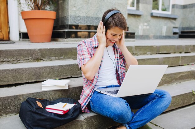 Junge Studenten genießen Kopfhörer und Laptop