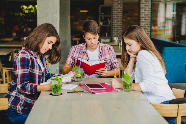 Junge Studenten im Cafe Hausaufgaben machen