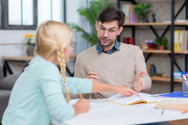 Junge Studentin, die dem Lehrer erklärt