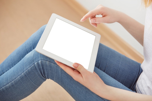 Junge Studentin, die in einer Universitätserholungshalle unter Verwendung des Touchpads sitzt