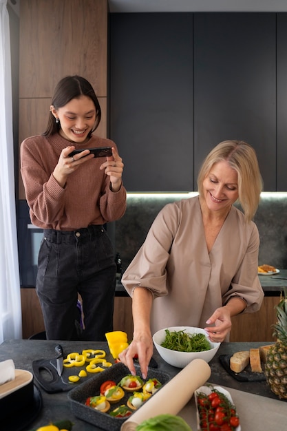 Kostenloses Foto junge und alte besties des mittleren schusses kochen