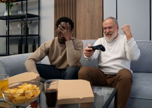 Junge und alte Freunde der Seitenansicht, die Videospiel spielen