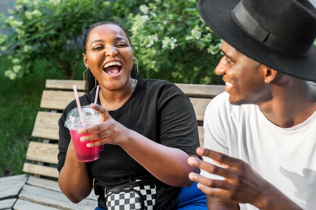 Junge und Mädchen genießen einige Smoothies im Freien