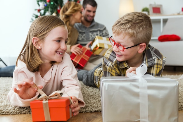 Junge und Mädchen mit einem roten Geschenk und einem silbernen Geschenk