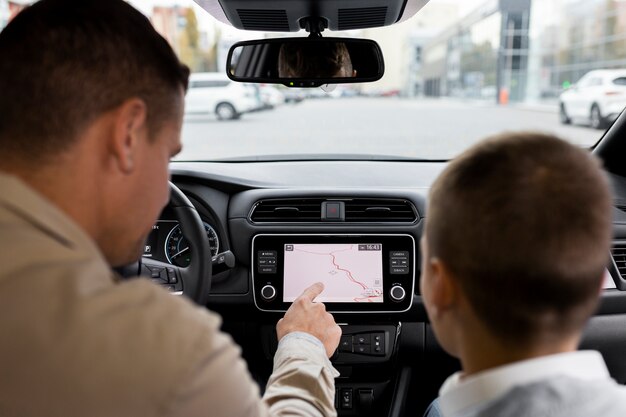 Junge und Papa in der Nähe eines Elektroautos