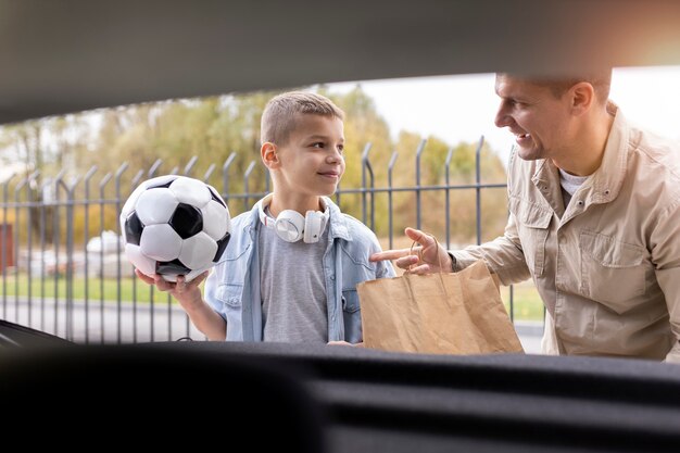 Junge und Papa in der Nähe eines Elektroautos