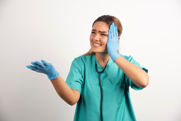 Junge weibliche Krankenschwester, die mit Stethoskop aufwirft.