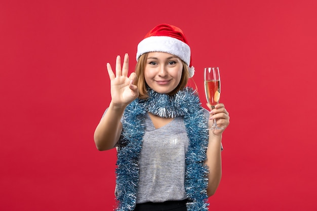 Junge weibliche Zählung der Vorderansicht, die Nummer auf Weihnachtsfeiertag der roten Wandfarbe zeigt