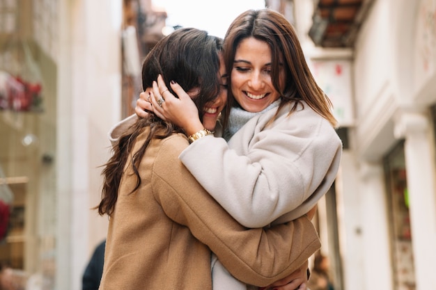 Junge zufriedene Frauen, die in der Liebe umfassen