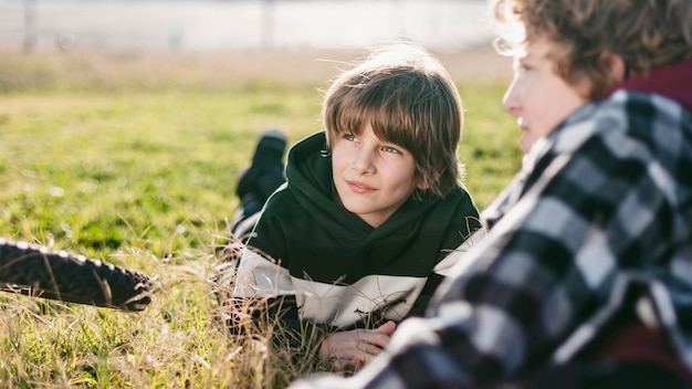 Kostenloses Foto jungen, die auf gras ruhen, während sie ihre fahrräder fahren