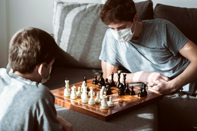 Jungen, die zu Hause Schach spielen, während sie unter Quarantäne gestellt werden