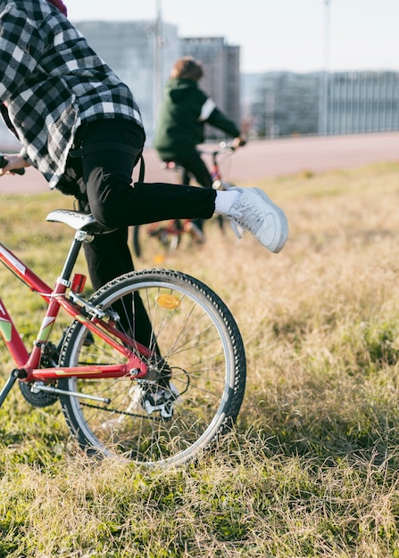 Jungen fahren ihre Fahrräder auf Gras im Freien