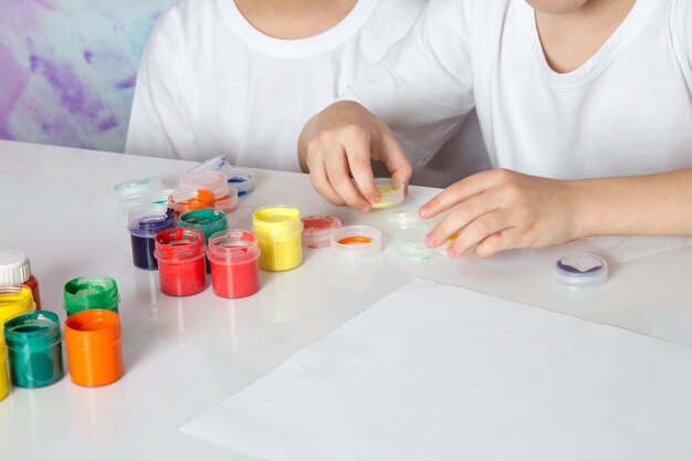 Jungen spielen mit bunten bunten Farben