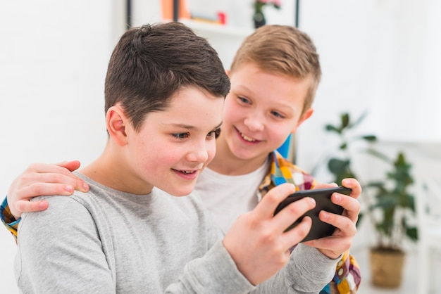 Kostenloses Foto jungen spielen mit dem smartphone