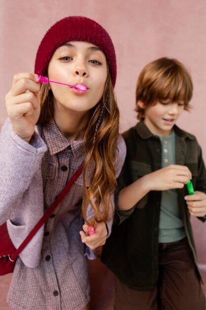 Jungen und Mädchen spielen mit Seifenblasen