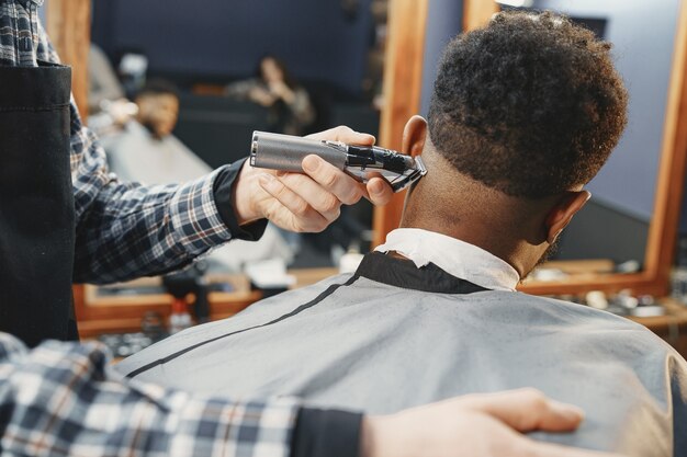 Junger afroamerikanischer Mann, der Friseursalon besucht