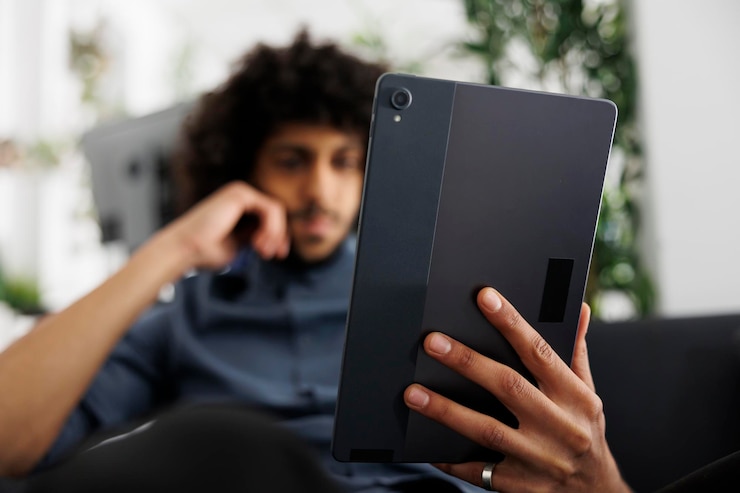 Kostenlose Foto junger arabischer unternehmer liest artikel auf digitalem tablet, während er im geschäftsbüro arbeitet. der geschäftsführer eines start-up-unternehmens überprüft die präsentation der projektmarketingstrategie