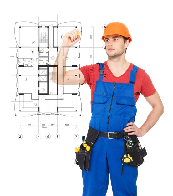 Junger Arbeiter, der das Schema eines neuen Hauses zeichnet