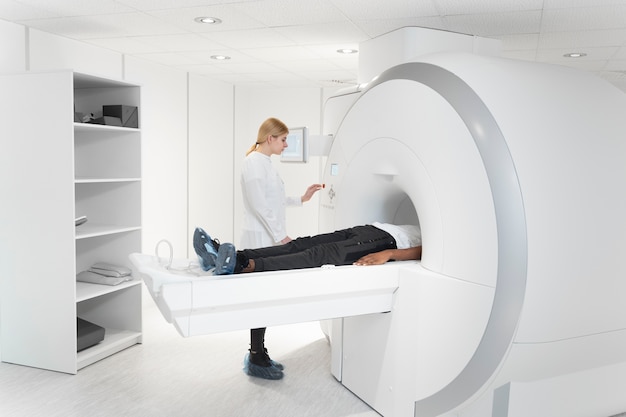 Junger Arzt, der CT-Scan-Tasten drückt