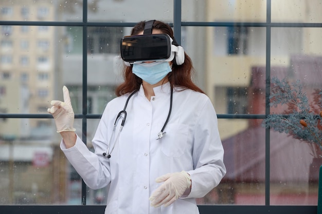 Junger Arzt, der eine VR-Brille trägt und mit dem Finger nach oben zeigt Foto in hoher Qualität