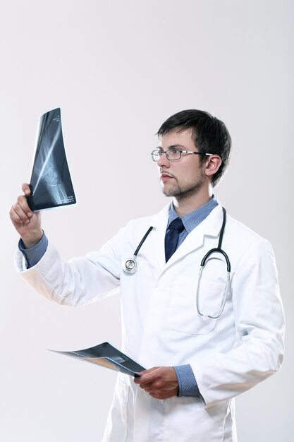Junger Arzt, der Röntgenbild betrachtet