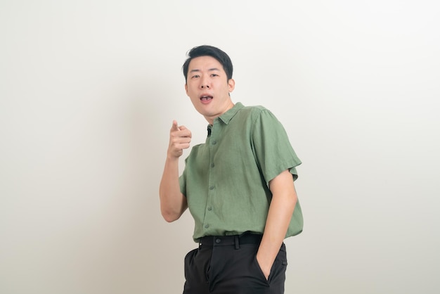 Junger asiatischer mann mit lustigem und verrücktem gesicht auf weißem hintergrund