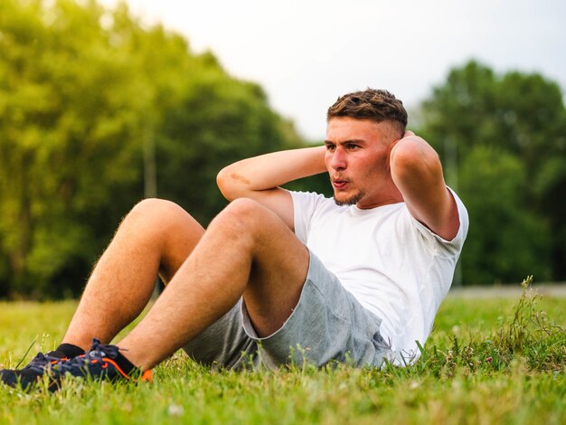 Junger attraktiver Sportler beim Training im Freien - Trainingskonzept