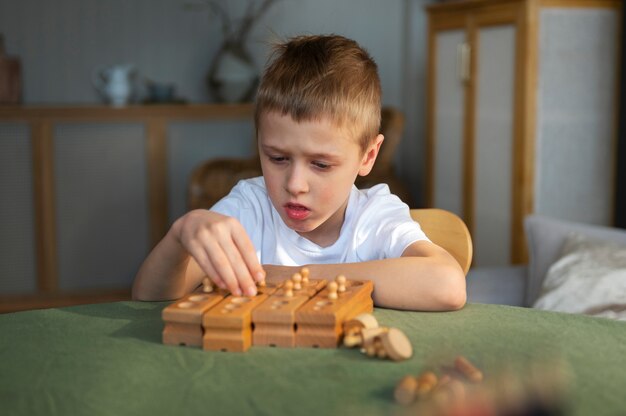 Junger autistischer Junge, der zu Hause mit Spielzeug spielt