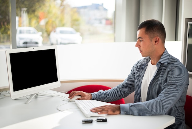 Junger Autohändler, der im Büro arbeitet