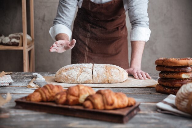 Junger Bäcker schnitt das Brot.