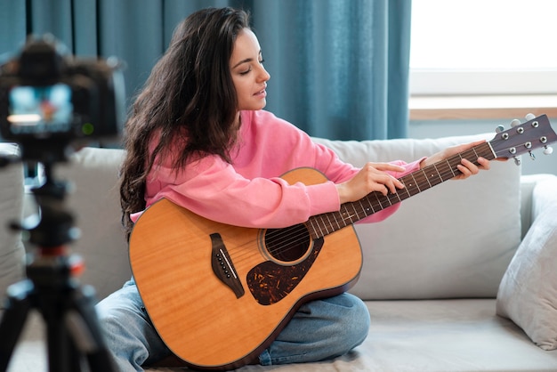 Kostenloses Foto junger blogger zeigt, wie man die finger in die gitarre legt